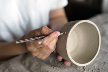 Fototapeta na wymiar Female hands hold a bowl for casting clay products. Shaped method for making clay dishes. Handwork. Pottery making