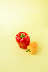 whole of yellow and red sweet bell pepper or capsicum on yellow background