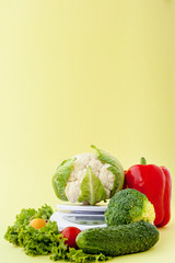 Fresh vegetables on vase on yellow background. Healthy eating, diet planning, weight loss, detox, organic farming concept