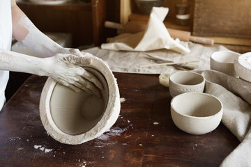 Female hands hold a bowl for casting clay products. Shaped method for making clay dishes. Handwork. Pottery making