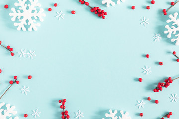 Christmas holiday composition. Xmas white decorations and red berries on pastel blue background. Christmas, New Year, winter concept. Flat lay, top view, copy space