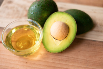 Avocado and avocado oil on a wooden background. Top view. Copy space for your text.