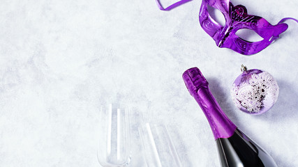 Christmas card with champagne glasses, bottle, carnival mask, christmas ornaments in pink colors.