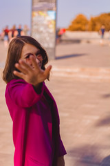 A girl in trendy plum and bright suit walks around the city and has fun. Style.