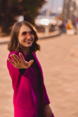 A girl in trendy plum and bright suit walks around the city and has fun. Style.