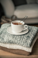 Toned photo. Autumn decor. A mug of hot tea, Knitted sweaters . Cozy. Autumn.