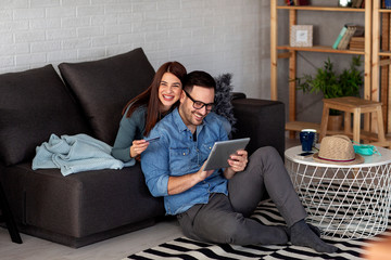 Couple with tablet and credit card shopping on line from home