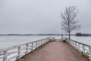 Small pier in Seurasaari island at cloudy, winter day, Finland.