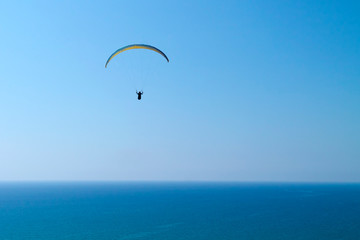 Paraglider in the sky over blue sea