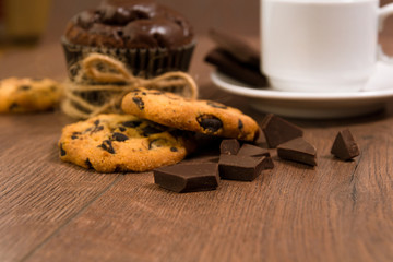 Chocolate muffin on a brown table. A cup of coffee. shortbread.