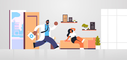 male doctor with first aid kit running to help woman patient medicine healthcare ambulance concept african american medical worker in white coat living room interior full length flat horizontal