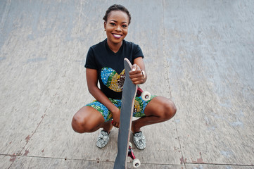 Young african american woman posed with skateboard in skate park. © AS Photo Family