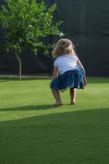 Niña rubia jugando en el césped / Little blonde girl playing on the grass