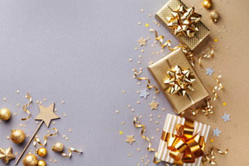 Golden gift or present boxes with golden bows and confetti top view. Christmas background. Flat lay.