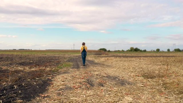 Female farmer walking on countryside dirt road