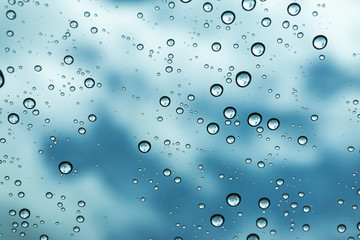 Fototapeta na wymiar Rain on the window, natural skin of the rain The natural form of rainwater on a sky background.