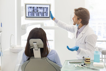 Dentist doctor showing his patient x-ray results