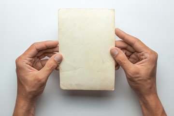 Old photo in the hands of man. Empty template for picture, mock-up. Gray background.