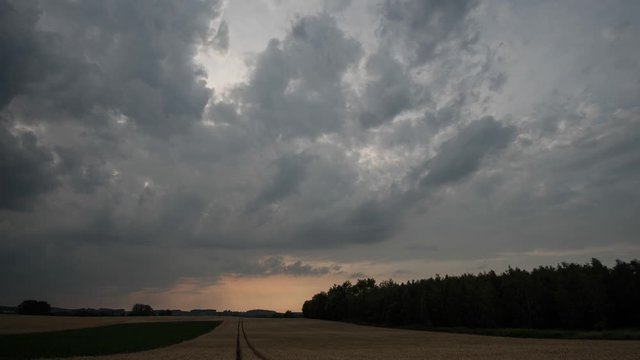 Rural landscape and low clouds scudding across sky in evening. Time lapse.
