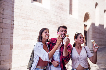 Group of tourist eating ice cream at street