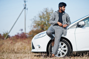 Naklejka premium Indian man at casual wear posed near white car.