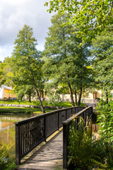 Wooden bridge across Fiskars river and trees, Fiskars village, Finland