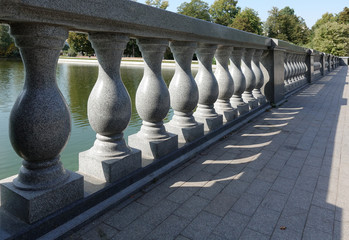 Concrete balustrade with classical pillars standing in a row. Beautiful detail of an old fence