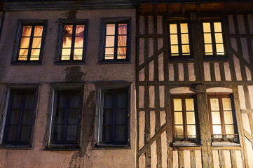 Windows of a historic house at night in the city of Troyes in France.