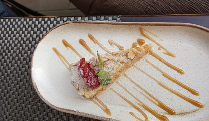 A slice of delicious sandwich puff cake with strawberries on a dish