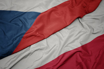 waving colorful flag of poland and national flag of czech republic.