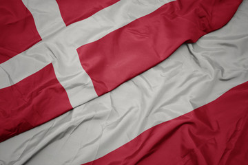 waving colorful flag of poland and national flag of denmark.
