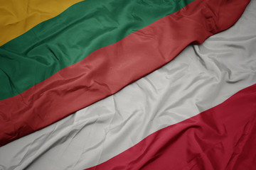 waving colorful flag of poland and national flag of lithuania.