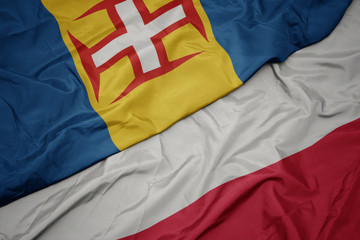 waving colorful flag of poland and national flag of madeira.