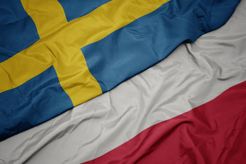 waving colorful flag of poland and national flag of sweden.