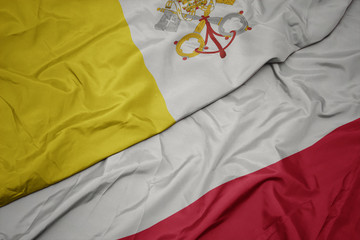 waving colorful flag of poland and national flag of vatican city.