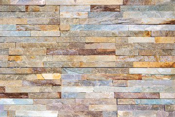 Decorative texture of a beautiful wall with rectangular parts of multi-colored artificial stone.