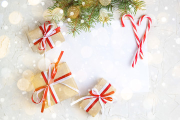 Clear paper laying with candy cane, Christmas tree branches and gifts