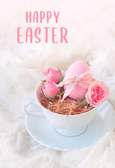 happy Easter greeting card. spring holiday concept. beautiful Easter still life. pink eggs and flowers roses in Cup on table background. soft selective focus