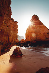 Beautiful sunrise view of a empty beach with rough sand stone rock coastline and nature view. Praia...