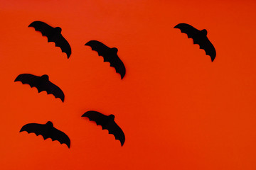 Naklejka premium Paper bats, a Jack-o ' - lantern on an orange background. Happy Halloween. Traditions, holidays concept. Space for your text. Top view. 