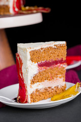 Beautiful and delicious dessert. The cake on the stand is decorated with red and yellow pears.