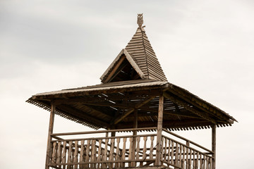 Wooden, vintage plank roof with an owl figure on top.