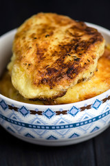 fried potato pancakes in bowl on dark wooden background