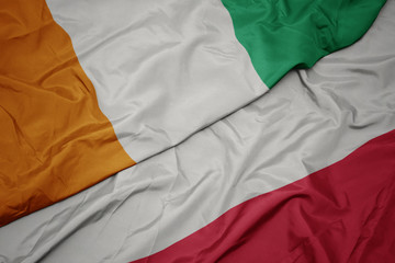 waving colorful flag of poland and national flag of cote divoire.