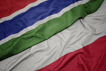 waving colorful flag of poland and national flag of gambia.