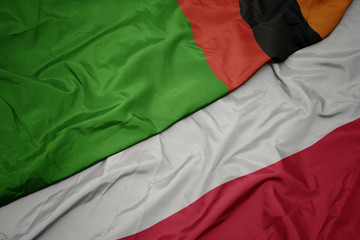 Fototapeta premium waving colorful flag of poland and national flag of zambia.