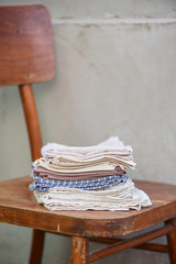 A stack of linen textiles on a wooden table