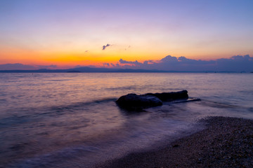 Idyllic sunrise sea wave and stone from Pefkochori