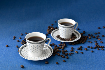 Two cups of coffee on blue background