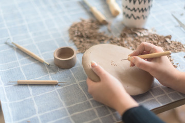 Pottery workshop, the process of making ceramic tableware, women's hands